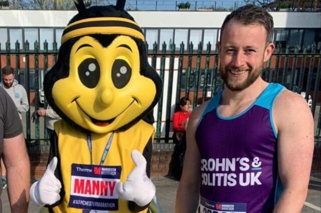 Josh stood next to bee mascot while wearing a Crohn's and Colitis marathon outfit